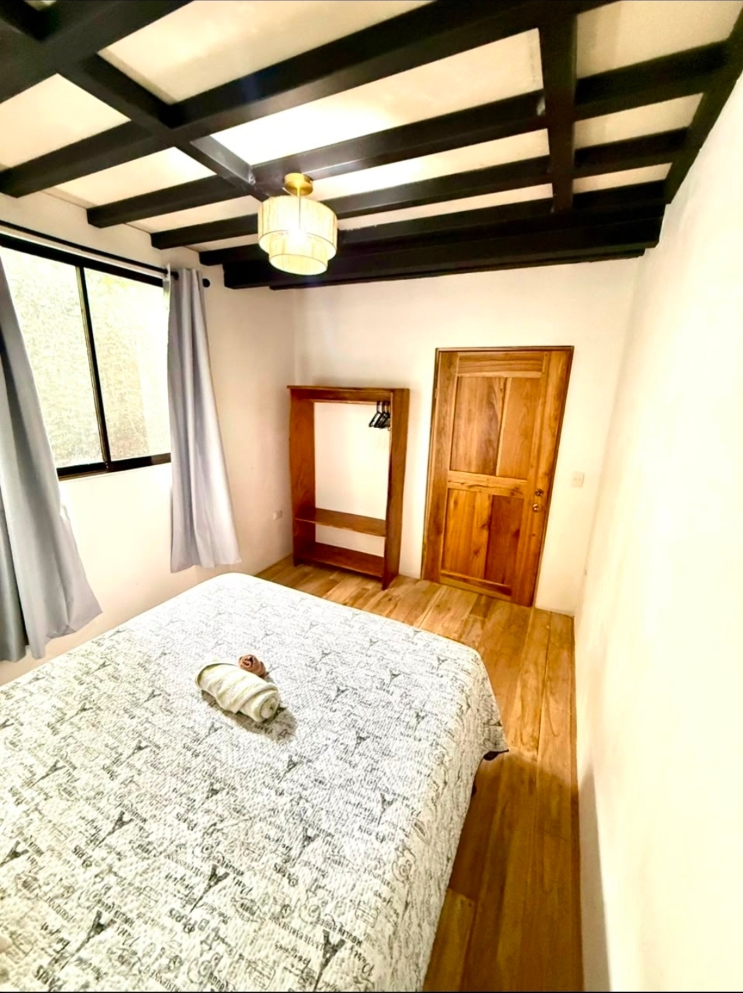 VIP bedroom with wardrobe, wooden floors, and jungle-facing window