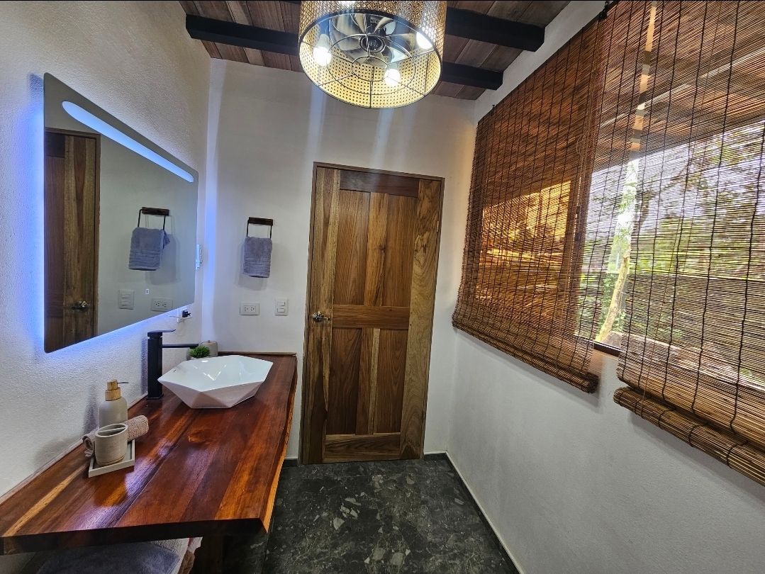VIP bathroom with live-edge wood vanity and backlit mirror