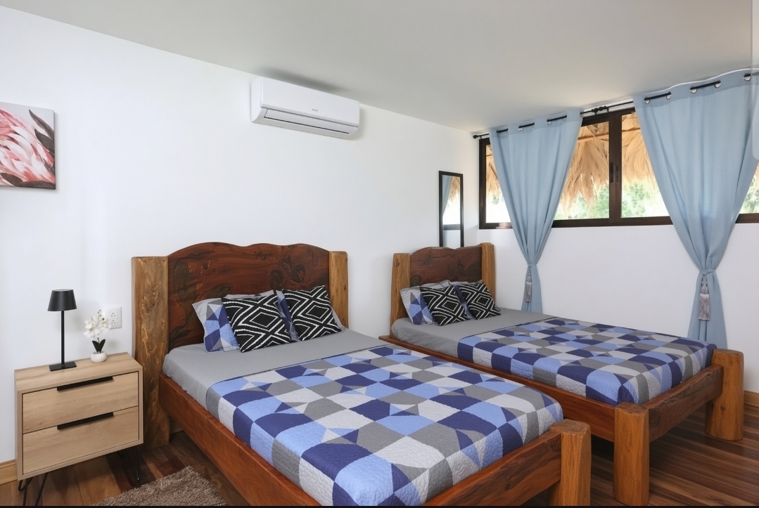 Two single beds with air conditioning in the shared enclosed room