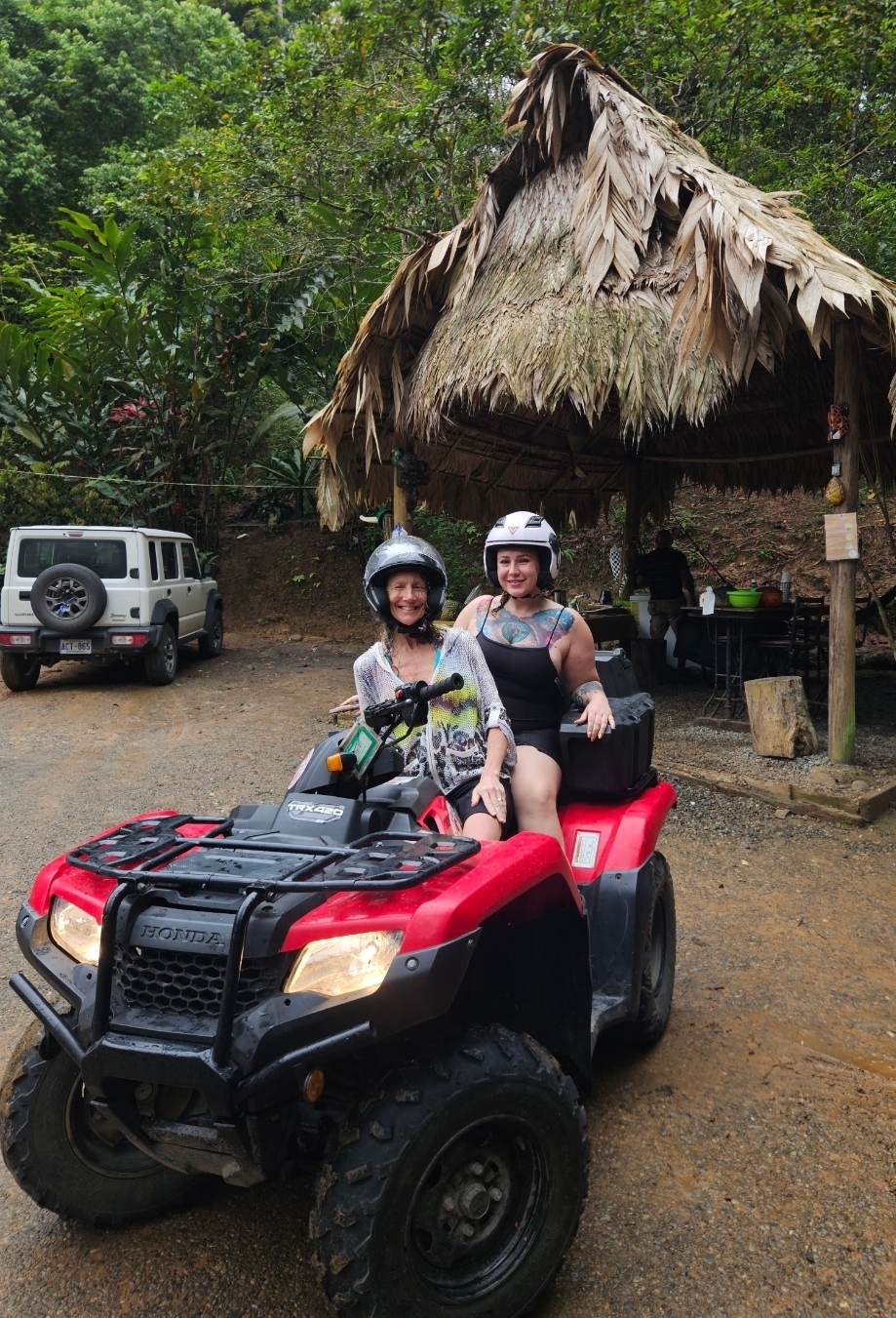 Two guests on an ATV at a jungle trailhead before a rainforest ride