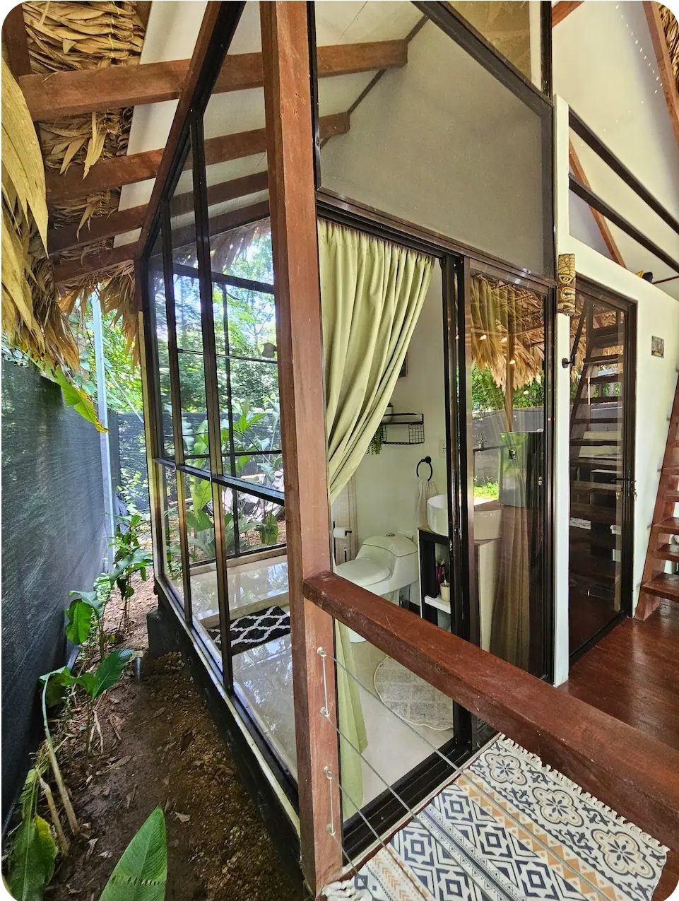 Bungalow bathroom with a glass wall facing the jungle
