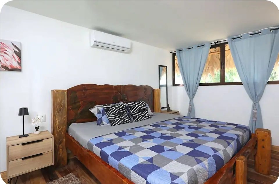 Bungalow bedroom with air conditioning and a wooden bed frame