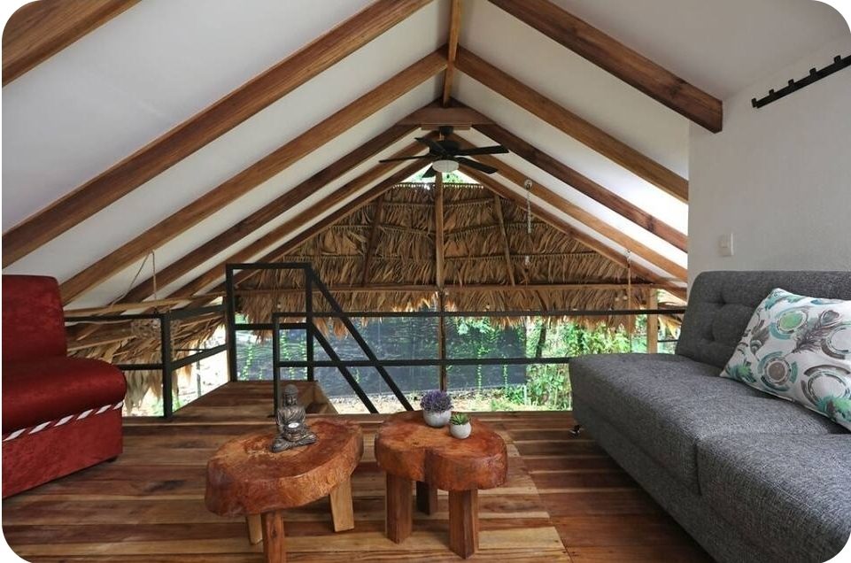 Open loft lounge under a thatched roof with wooden beams