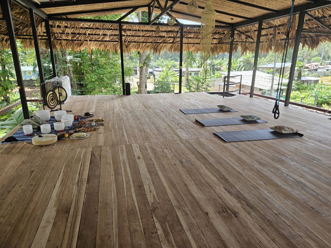 Open-air thatched ceremony deck surrounded by jungle at Evolution House