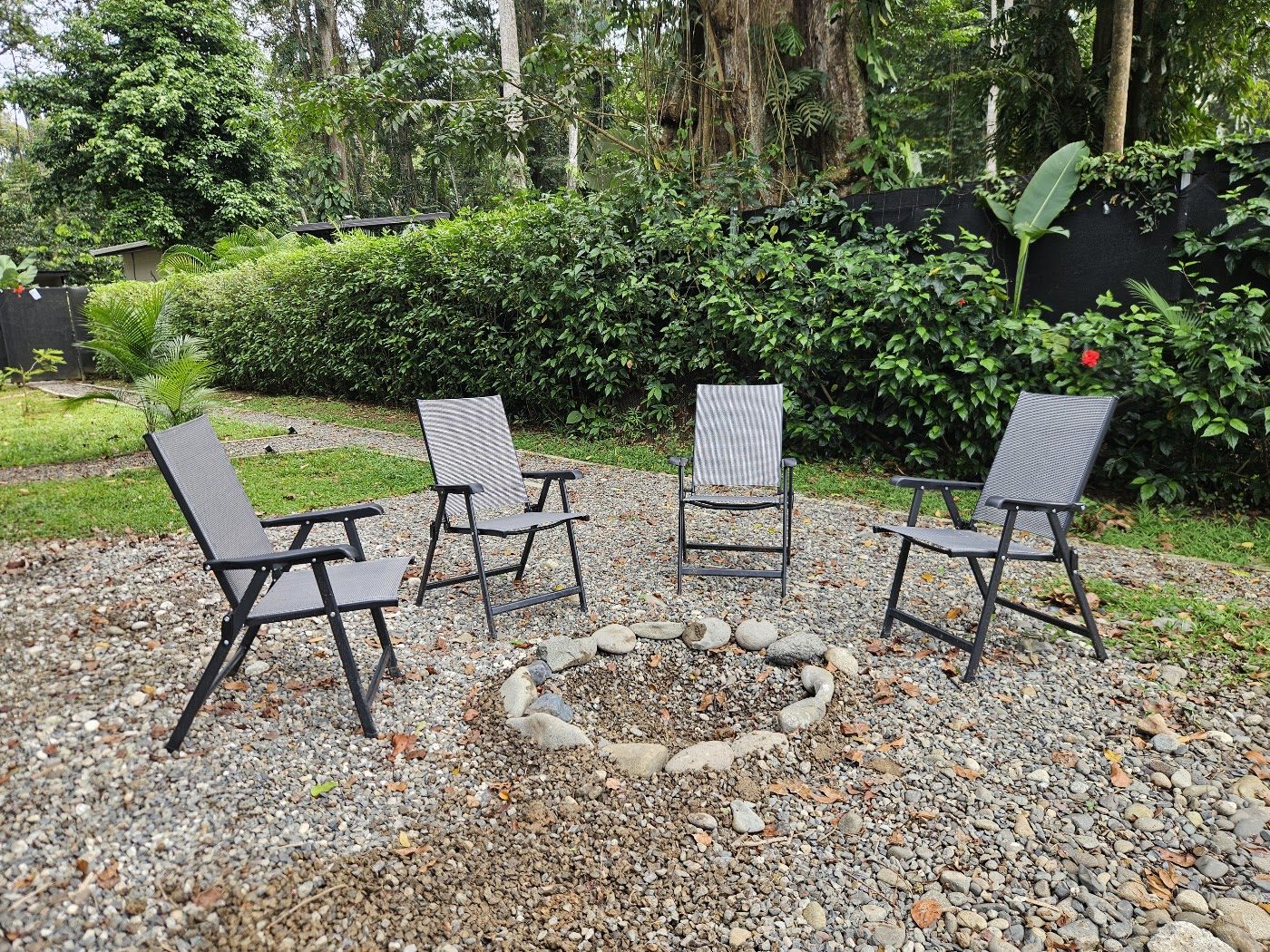 Outdoor fire circle with seating in the garden at Evolution House