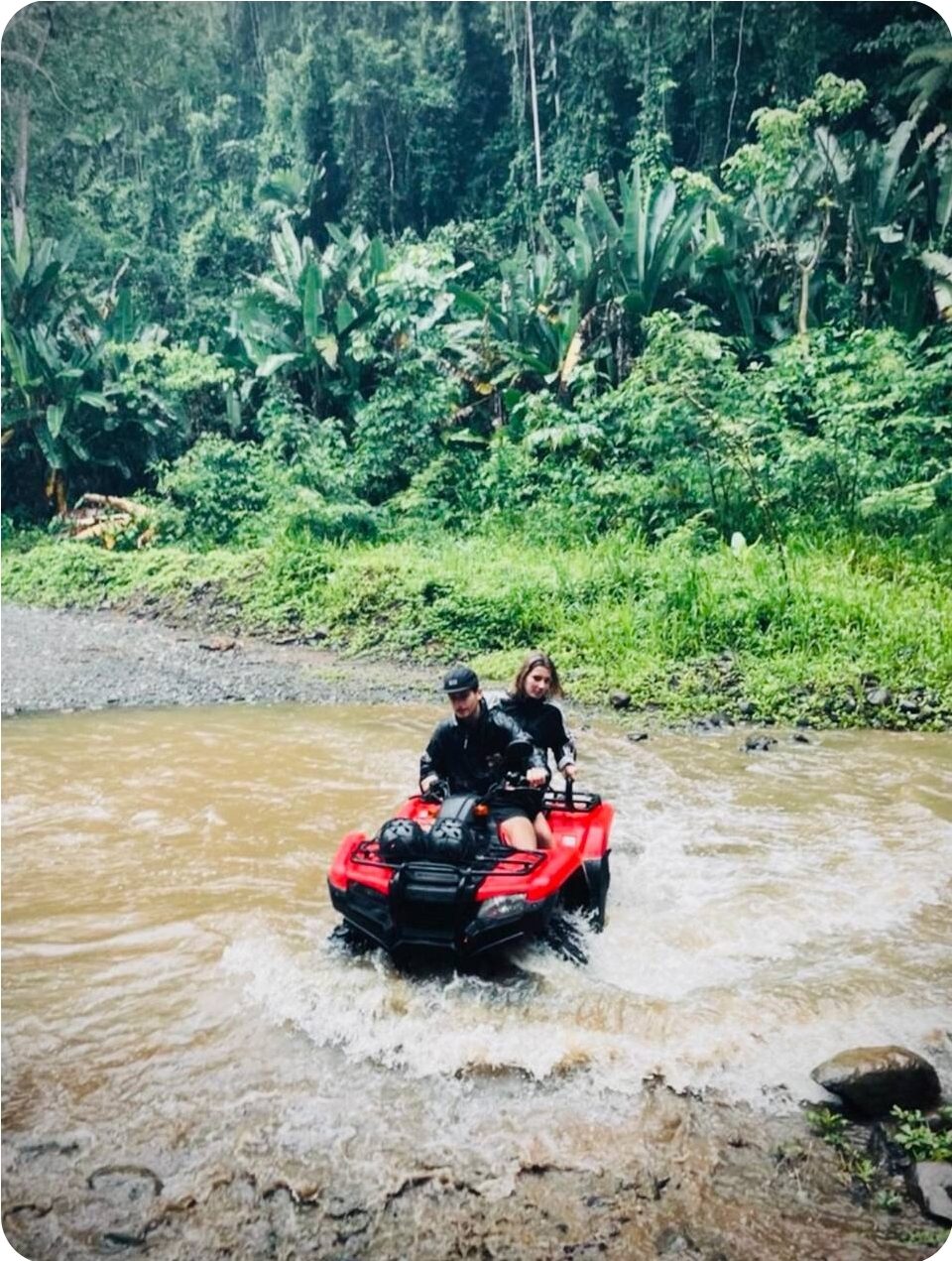Quad rider on a jungle trail heading to a waterfall